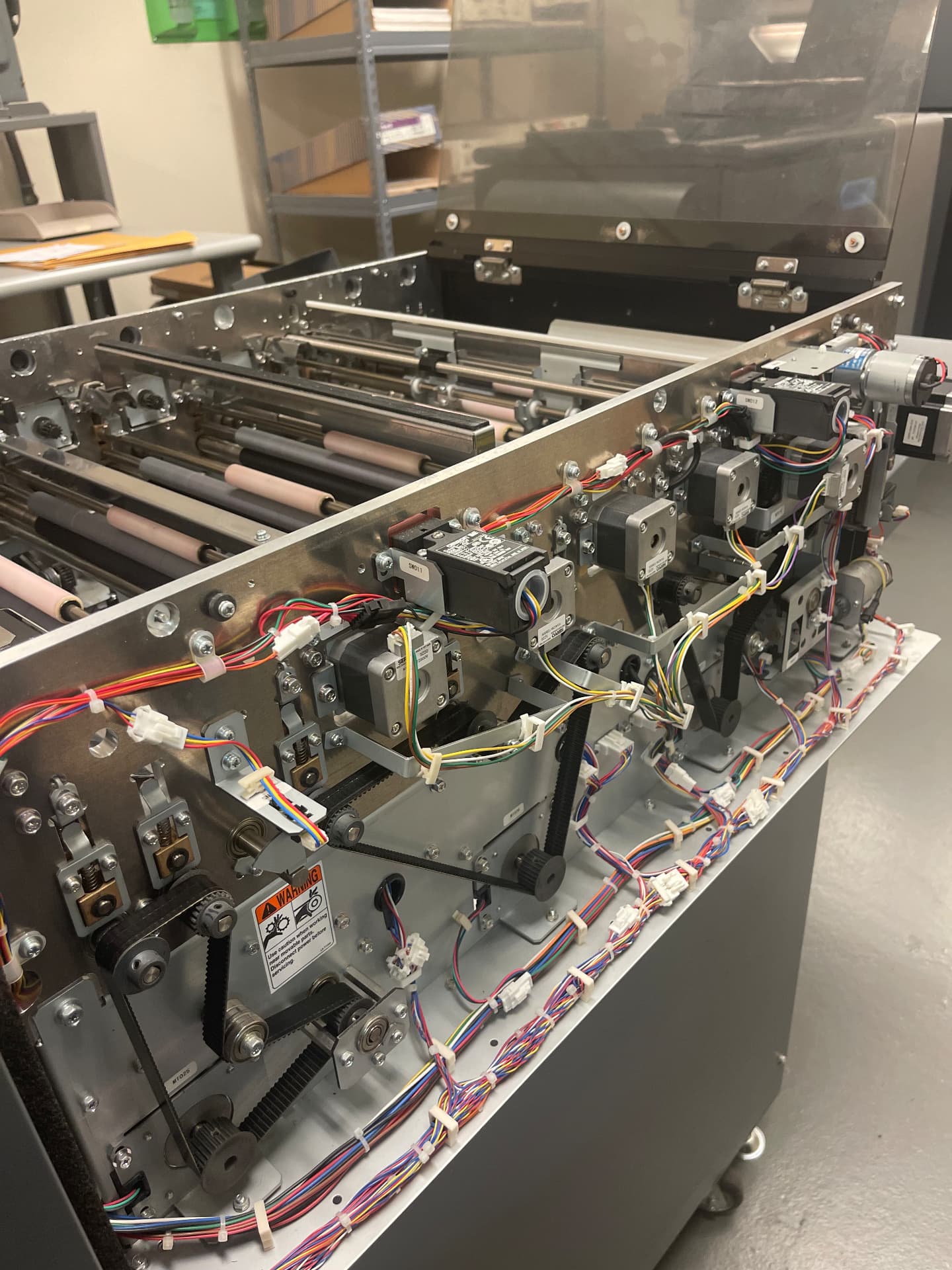Close-up of SBR-NE diagnostics and repair work on print-finishing equipment drive assemblies